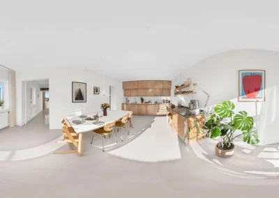 High-quality 360 panorama of a bright, modern kitchen and dining area for real estate virtual tours.
